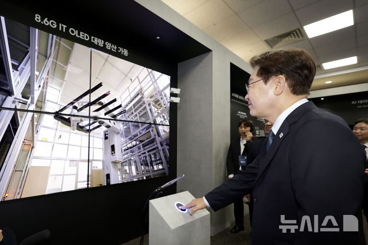 [아산=뉴시스] 최동준 기자 = 이재명 대통령이 2일 충남 아산시에서 열린 충청권 첨단산업 발전비전 국민보고회에서 삼성디스플레이의 주요 제품을 관람하며 유리 기판을 라인에 투입하는 버튼을 터치하고 있다. 이 유리 기판은 세계 최초 8.6세대 OLED 디스플레이 양산을 위한 첫 투입이다. 2026.07.02. photocdj@newsis.com