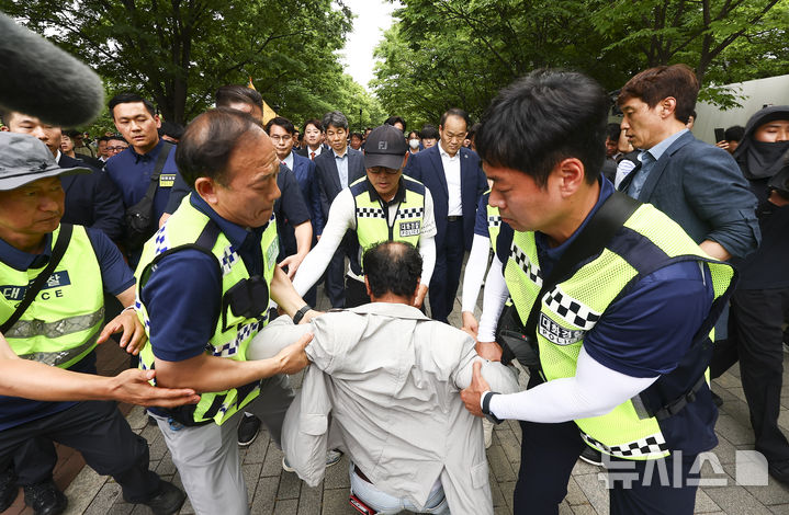 [서울=뉴시스] 김근수 기자 = 윤상현 국조특위 위원장과 6·3 지방선거 투표용지 부족 사태를 조사 중인 국회 국정조사특별위원회 위원들이 2일 서울 송파구 올림픽공원 내 개표소 내부로 이동하는 도중 한 시위 참가자가 달려들고 있다. 2026.07.02. ks@newsis.com