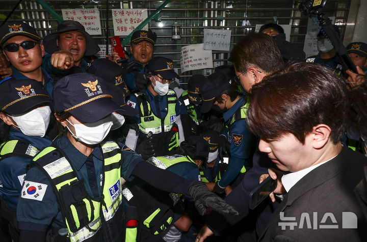 [서울=뉴시스] 김근수 기자 = 6·3 지방선거 투표용지 부족 사태를 조사 중인 국회 국정조사특별위원회 위원들이 2일 서울 송파구 올림픽공원 내 개표소를 찾은 가운데 출입문을 가로막은 시위 참가자가 경찰에 연행되고 있다. 2026.07.02. ks@newsis.com