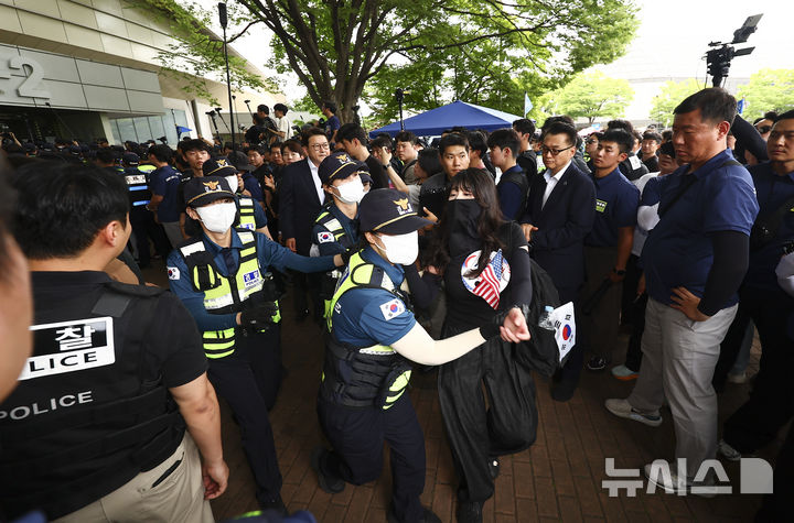 [서울=뉴시스] 김근수 기자 = 6·3 지방선거 투표용지 부족 사태를 조사 중인 국회 국정조사특별위원회 위원들이 지난 2일 서울 송파구 올림픽공원 내 개표소를 찾은 가운데 출입문을 가로막은 시위 참가자가 경찰에 연행되고 있다. 2026.07.02. ks@newsis.com