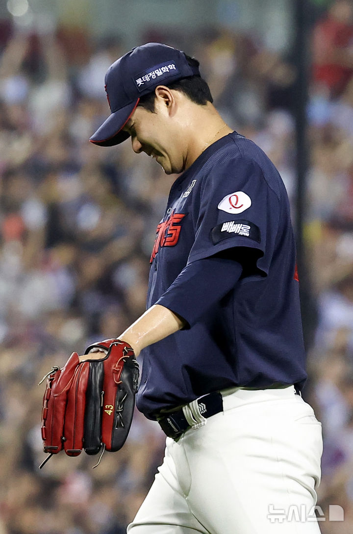 [서울=뉴시스] 김선웅 기자 = 2일 서울 송파구 잠실야구장에서 열린 2026 프로야구 롯데 자이언츠 vs 두산 베어스 경기, 3회말 2사 주자 1,3루 상황 롯데 선발투수 나균안이 두산 박준순을 삼진으로 잡아내고 미소지으며 더그아웃으로 복귀하고 있다. 2026.07.02. mangusta@newsis.com