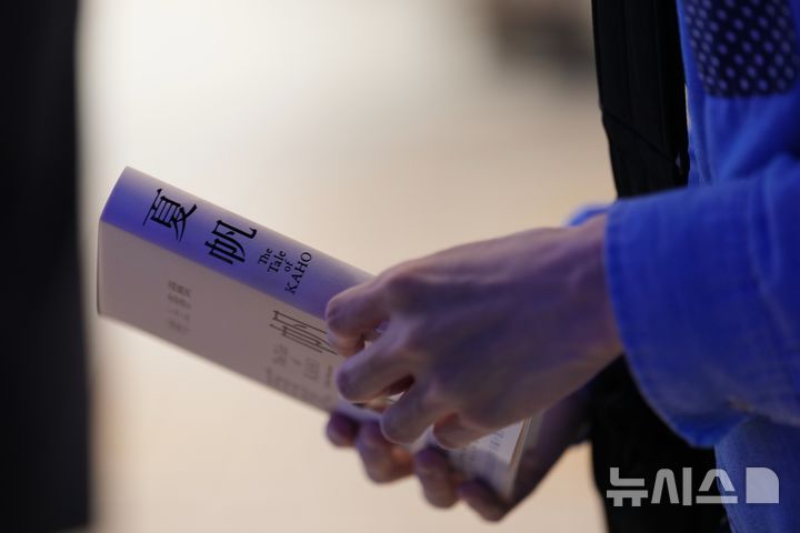 [도쿄=AP/뉴시스] 일본 도쿄의 한 기노쿠니야 서점에서 나오유키 야마노가 지난달 3일 자정 카운트다운 행사 직후 사전 구매한 무라카미 하루키의 신작 '카호 이야기'를 들고 있다. 최근 일본에서는 생성형 AI를 활용한 것으로 추정되는 소설이 신인 문학상에 몰리면서 응모작과 심사 부담이 함께 늘어 논란이 일고 있다. 2026.07.03.