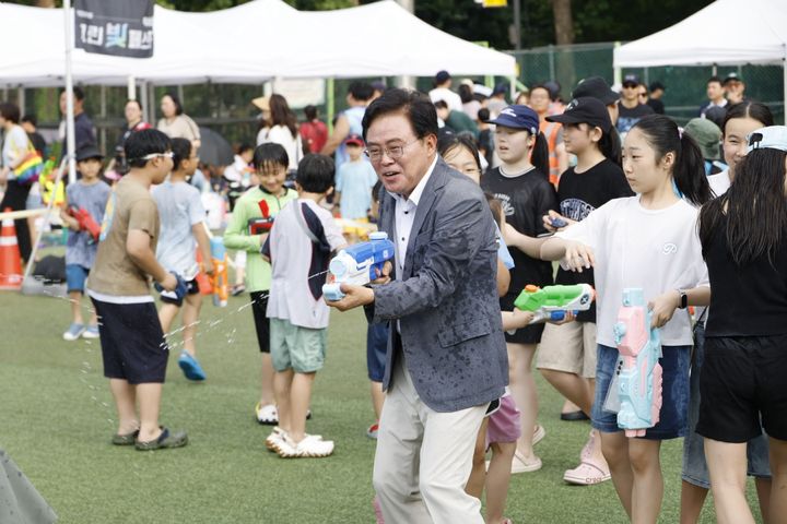 [서울=뉴시스] 진교훈 서울 강서구청장이 4일 우장산 축구장에서 열린 '그린 빛 페스타'에서 아이들과 물총놀이를 하고 있다. (사진=강서구 제공) 2026.07.04. photo@newsis.com *재판매 및 DB 금지