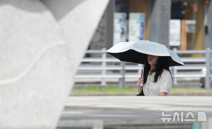 [제주=뉴시스] 우장호 기자 = 제주지역에 올해 첫 폭염특보가 발효된 6일 오전 제주시 이도2동 거리에서 양산을 쓴 시민들이 걸어가고 있다. 2026.07.06. woo1223@newsis.com