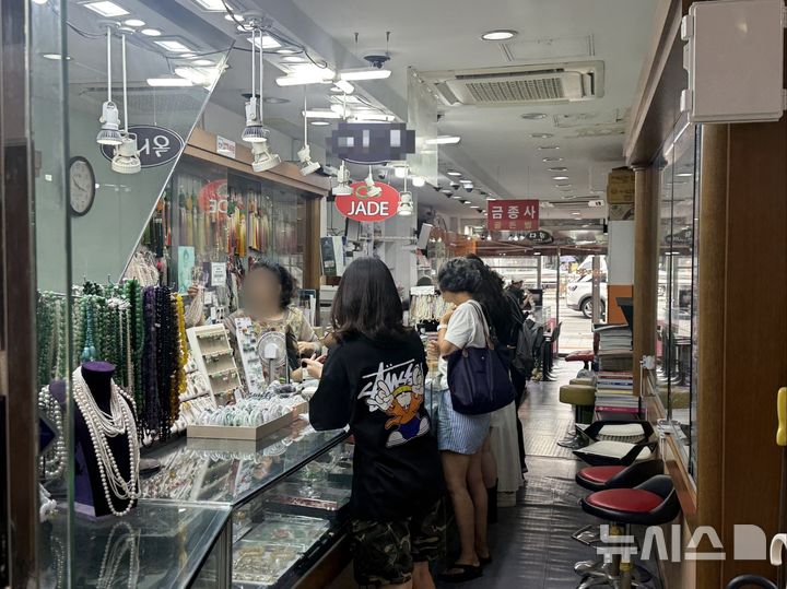 [서울=뉴시스] 이송이 인턴기자, 이지윤 인턴기자 = 6일 서울 종로구 귀금속 거리의 옥 전문점에서 방문객들이 옥반지를 살펴보고 있다. 2026.07.06.