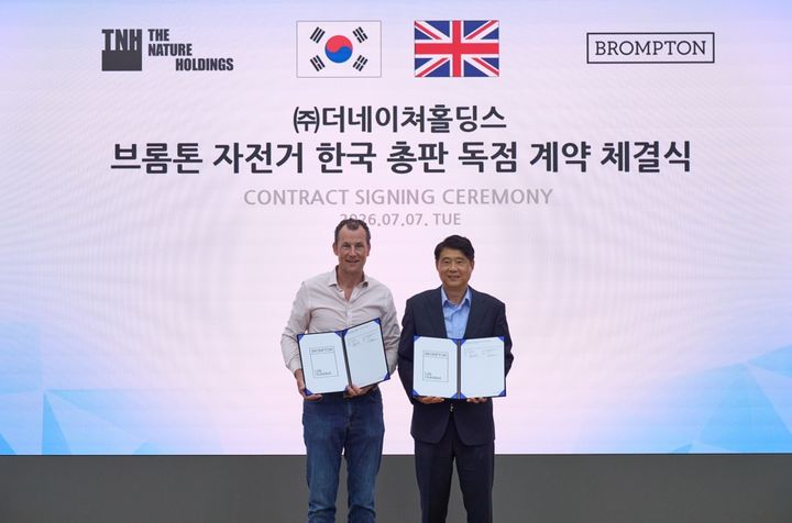 [서울=뉴시스] 라이프스타일 전문기업 더네이쳐홀딩스가 영국 프리미엄 폴딩 자전거 브랜드 브롬톤(BROMPTON)과 자전거 한국 총판 계약을 체결했다. 윌 버틀러-아담스 대표(왼쪽)와 박영준 더네이쳐홀딩스 대표(오른쪽)가 기념사진을 촬영하고 있다. (사진=더네이쳐홀딩스 제공) 2026.07.07. photo@newsis.com *재판매 및 DB 금지