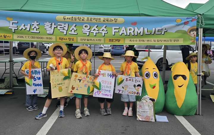 [울산=뉴시스] 울산 두서초 학생들이 7일 언양시장에서 직접 수확한 옥수수를 판매 준비를 하고 기념사진을 찍고있다. (사진=울산시교육청 제공) 2026.07.07 photo@newsis.com *재판매 및 DB 금지
