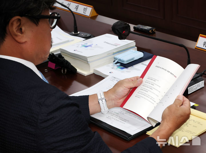 [세종=뉴시스] 배훈식 기자 = 권순원 최저임금위원회 위원장이 7일 오후 세종시 정부세종청사에서 열린 최저임금위 제12차 전원회의에서 전달받은 '민주노총 최저임금 글 공모전 수기집'을 살펴보고 있다. 2026.07.07. dahora83@newsis.com