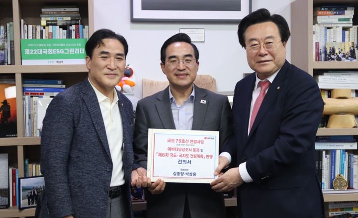 [창원=뉴시스] 강경국 기자 = 국민의힘 김종양 의원(왼쪽)이 8일 박홍근 기획예산처 장관(가운데)에게 국도 79호선 창원 북면~창녕 부곡 연결 사업의 예비타당성조사 통과와 제6차 국도·국지도 건설계획 반영을 요청하는 건의서를 전달하고 있다. (사진=김종양 의원실 제공). 2026.07.08. photo@newsis.com *재판매 및 DB 금지