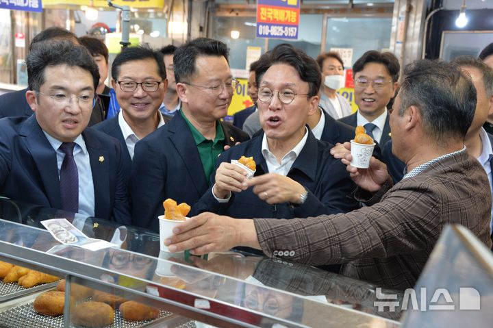 [목포=뉴시스]박상수 기자 = 8일 오후 전남광주 목포시 동부시장을 찾은 김민석 전 국무총리가 꽈배기를 주위사람들과 나누어 먹고 있다. 2026,07.08. parkss@newsis.com