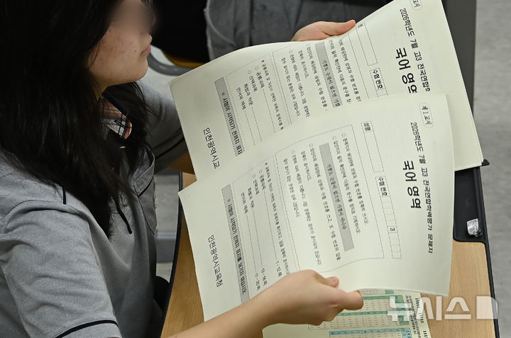 [수원=뉴시스] 김종택 기자 = 7월 전국연합학력평가가 실시된 8일 경기 수원시 권선고등학교 3학년 교실에서 한 학생이 문제지를 전달받고 있다. 2026.07.08. jtk@newsis.com