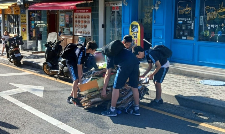 [부산=뉴시스] 부산 영도구에서 폐지 줍는 어르신을 돕고 있는 중학생들. (사진=부산교육청 제공) 2026.07.09. photo@newsis.com *재판매 및 DB 금지