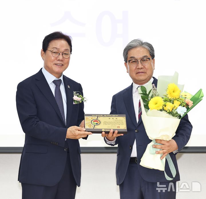 [창원=뉴시스]박완수(왼쪽) 경남도지사가 9일 오후 창원특례시 경남자유회관에서 열린 한국자유총연맹 경남지부 회장 이·취임식에 참석해 김용수 이임회장에게 감사패를 수여한 후 기념촬영하고 있다.(사진=경남도 제공) 2026.07.09. photo@newsis.com 