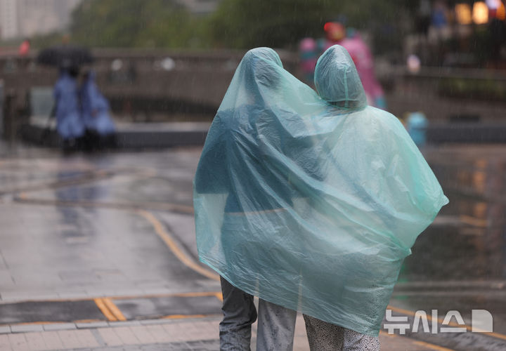 [서울=뉴시스] 김명년 기자 = 많은 비가 내린 9일 오전 서울 중구 한 거리에서 시민들이 우비를 함께 입고 이동하고 있다. 2026.07.09. kmn@newsis.com