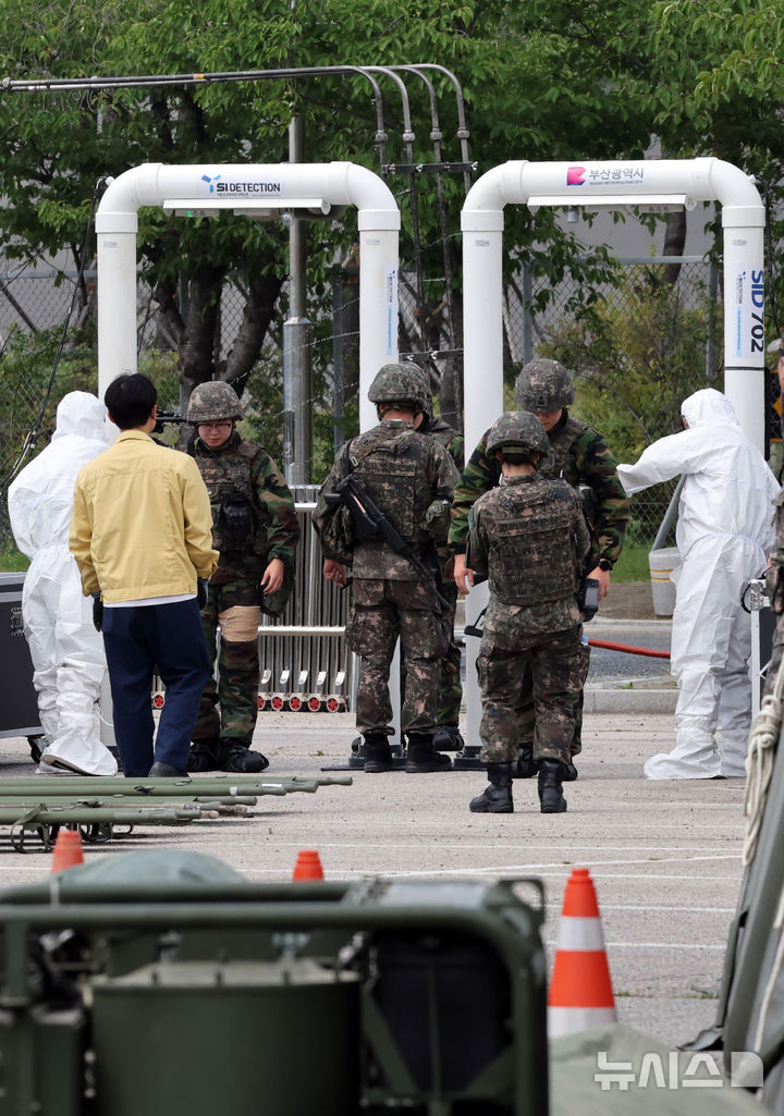  [부산=뉴시스] 하경민 기자 = '핵·대량살상무기(WMD) 사후관리 훈련'이 열린 9일 부산 강서구 렛츠런파크 부산경남에서 관계자들이 이송된 군 장병들을 대상으로 방사능 오염 여부를 확인하고 있다. 이날 훈련에는 53사단과 부산시, 부산소방재난본부, 부산경찰청 등 29개 지자체 및 기관이 참가했다. 2026.07.09. yulnetphoto@newsis.com