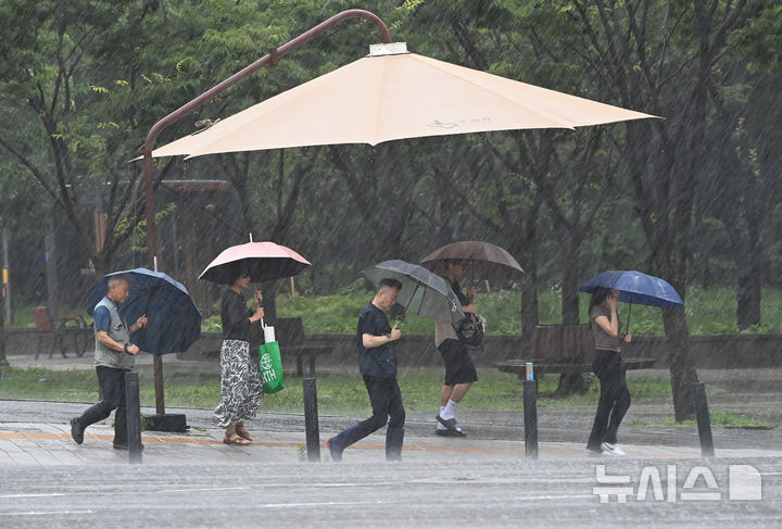 [수원=뉴시스] 김종택 기자 = 전국 곳곳에 호우특보가 발효된 9일 경기 수원시 영통구 영통동에서 우산을 쓴 시민들이 횡단보도를 건너고 있다. 2026.07.09. jtk@newsis.com