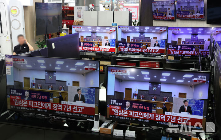 [서울=뉴시스] 김명년 기자 = 9일 오후 서울 용산구 용산전자상가 TV 매장에서 지난 12·3 비상계엄 이후 고위공직자범죄수사처의 체포영장 집행을 방해한 혐의 등으로 기소된 윤석열 전 대통령에 대한 대법원의 징역 7년 확정 판결 뉴스가 나오고 있다. 2026.07.09. kmn@newsis.com