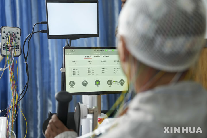 [라싸(중국)=신화/뉴시스] 중국 상하이의 한 병원에서 세계 최초로 뇌-컴퓨터 인터페이스(BCI) 장치의 상업용 이식 시술에 성공했다. 사진은 지난 9일 중국 시짱(西藏·티베트의 중국식 명칭)자치구의 라싸 인민병원에서 하반신 마비 환자가 BCI 보조 신경 재활 치료를 받는 모습으로 기사와 직접 관련 없음. 2026.07.16