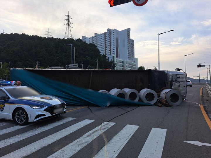 [부산=뉴시스] 10일 오전 5시40분께 부산 사하구의 한 교차로에서 25t 트럭이 유턴을 하던 중 적재함에 실려 있던 코일이 한쪽으로 쏠리면서 전도됐다. (사진=부산경찰청 제공) 2026.07.10. photo@newsis.com *재판매 및 DB 금지