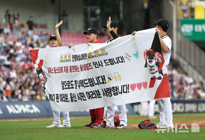 [서울=뉴시스]김선웅 기자 = 10일 서울 송파구 잠실야구장에서 열린 2026 KBO 퓨처스 올스타전 경기, 퓨처스 올스타전에 첫 출전하는 울산 웨일즈 선수들이 현수막을 들고 그라운드에 오르며 야구팬들에게 인사하고 있다. 2026.07.10. mangusta@newsis.com