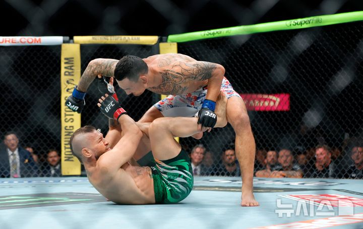 [라스베이거스=AP/뉴시스] 코너 맥그리거(왼쪽), 맥스 할로웨이와의 'UFC 329: 맥그리거 vs 할로웨이 2' 대회 메인 이벤트 웰터급(77.1㎏) 매치에서 1라운드 1분9초 만에 TKO 패배. 2026.07.11.