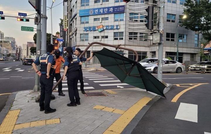 [제주=뉴시스] 11일 오후 7시39분께 제주시 삼도1동에서 강풍에 햇볕가리개 하단부가 뽑혀 소방당국이 안전조치를 진행하고 있다. (사진=제주소방안전본부 제공) 2026.07.12. photo@newsis.com *재판매 및 DB 금지