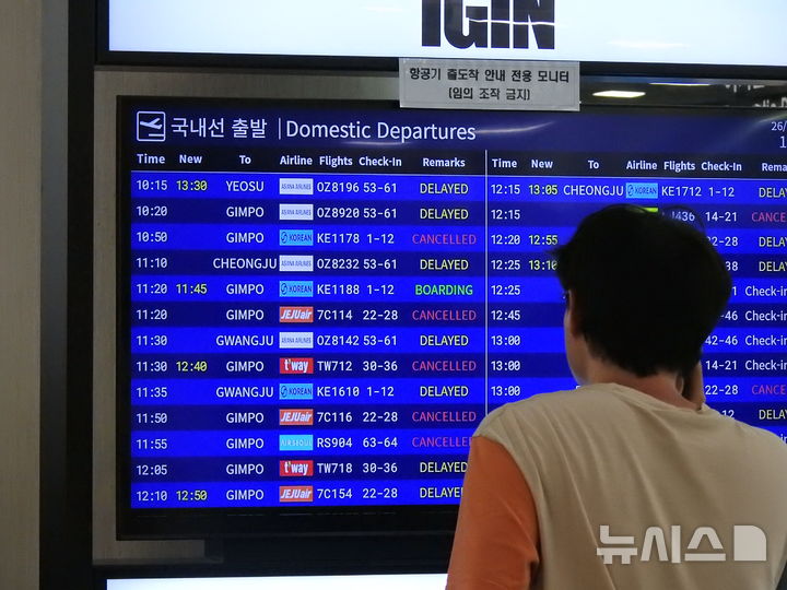 [제주=뉴시스] 김수환 기자 = 12일 오전 제주국제공항 출국장에서 여행객이 항공기 출도착 안내 모니터를 바라보고 있다.한국공항공사 제주공항에 따르면 이날 낮 12시 기준 국내선 102편(출발 48편, 도착 54편)과 국제선 2편(출발 1편, 도착 1편) 등 총 104편이 결항하고 국제선 도착 3편(홍콩, 다싱, 마카오 각 1편)이 회항했다. 2026.07.12. notedsh@newsis.com
