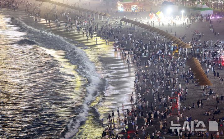  [부산=뉴시스] 하경민 기자 = 밤낮으로 푹푹 찌는 더위가 이어진 11일 밤 부산 수영구 광안리해수욕장에서 시민과 관광객들이 더위를 식히고 있다. 부산에는 지난 6일부터 폭염특보가 발효 중이며, 열대야도 지난 11일부터 이틀째 이어졌다. 2026.07.12. yulnetphoto@newsis.com