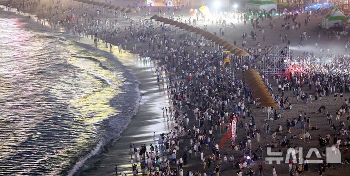  [부산=뉴시스] 하경민 기자 = 밤낮으로 푹푹 찌는 더위가 이어진 11일 밤 부산 수영구 광안리해수욕장에서 시민과 관광객들이 더위를 식히고 있다. 부산에는 지난 6일부터 폭염특보가 발효 중이며, 열대야도 지난 11일부터 이틀째 이어졌다. 2026.07.12. yulnetphoto@newsis.com