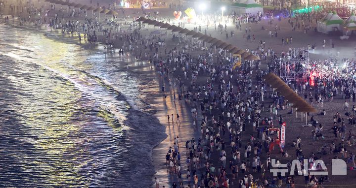  [부산=뉴시스] 하경민 기자 = 밤낮으로 푹푹 찌는 더위가 이어진 11일 밤 부산 수영구 광안리해수욕장에서 시민과 관광객들이 더위를 식히고 있다. 부산에는 지난 6일부터 폭염특보가 발효 중이며, 열대야도 지난 11일부터 이틀째 이어졌다. 2026.07.12. yulnetphoto@newsis.com