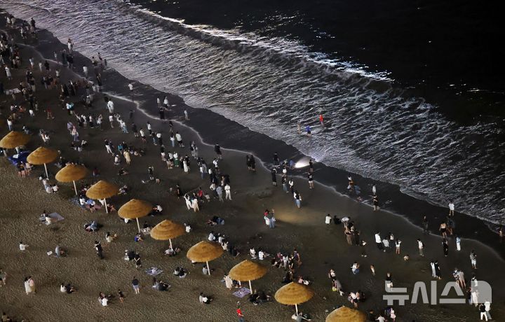  [부산=뉴시스] 하경민 기자 = 밤낮으로 푹푹 찌는 더위가 이어진 11일 밤 부산 수영구 광안리해수욕장에서 시민과 관광객들이 더위를 식히고 있다. 2026.07.12. yulnetphoto@newsis.com