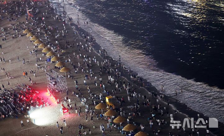  [부산=뉴시스] 하경민 기자 = 밤낮으로 푹푹 찌는 더위가 이어진 11일 밤 부산 수영구 광안리해수욕장에서 시민과 관광객들이 더위를 식히고 있다. 부산에는 지난 6일부터 폭염특보가 발효 중이며, 열대야도 지난 11일부터 이틀째 이어졌다. 2026.07.12. yulnetphoto@newsis.com