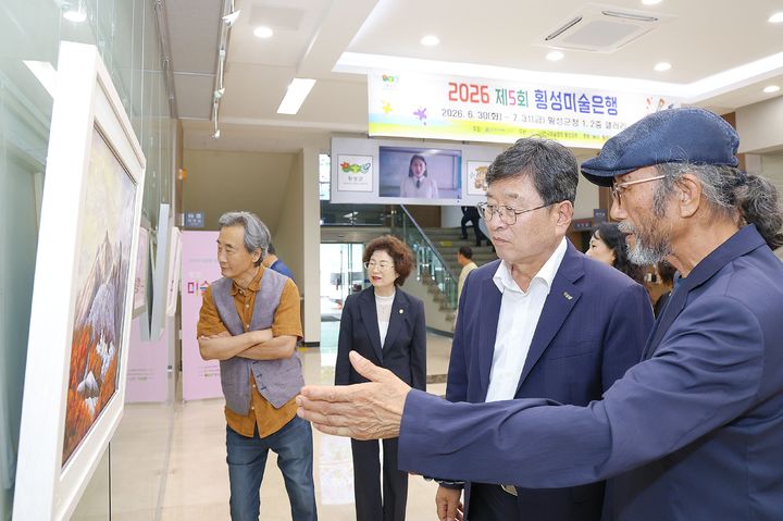 [횡성=뉴시스] 장신상 횡성군수가 군청 로비에서 열린 제5회 횡성미술은행 전시를 둘러보고 있다. (사진=횡성군 제공) 2026.07.13. photo@newsis.com *재판매 및 DB 금지