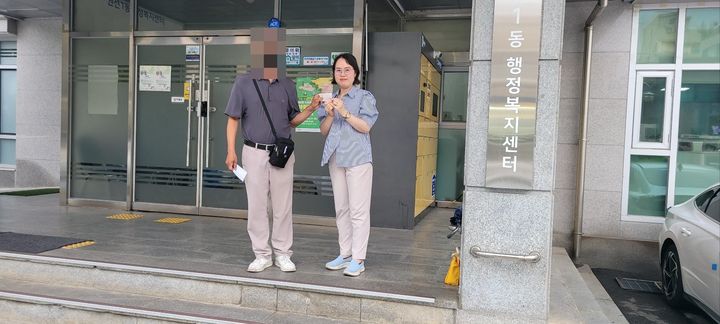 [수원=뉴시스] 주민등록증을 발급받은 김영수(가명)씨가 김경숙 베테랑팀장과 주민등록증을 들고 있다. (사진=수원시 제공) 2026.07.13. photo@newsis.com *재판매 및 DB 금지