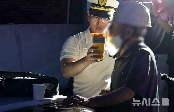[제주=뉴시스] 오영재 기자 = 제주경찰청과 제주도자치경찰단이 13일 오후 제주시 용담동 소재 도로에서 열린 휴가철 음주운전 합동 단속에서 음주운전을 적발해 재측정하고 있다. 이 운전자는 면허정지 수치의 혈중알코올농도가 측정됐다. 2026.07.13. oyj4343@newsis.com