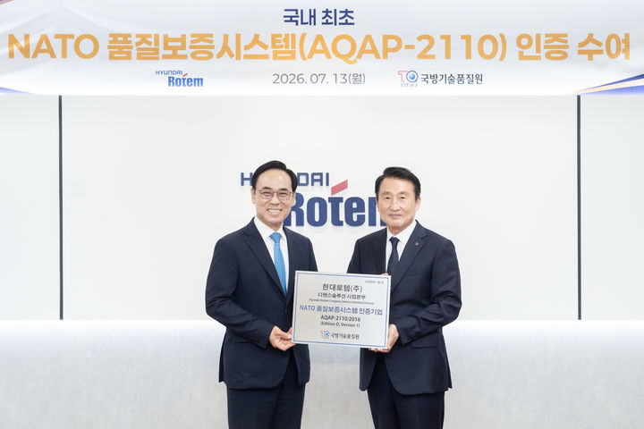 [서울=뉴시스] 이용배 현대로템 사장(왼쪽)이 지난 13일 경기 의왕시 본사에서 신상범 기품원장과 북대서양기구(NATO) 품질보증시스템 인증 수여식을 마친 후 기념촬영을 하고 있다. (사진=현대로템 제공) 2026.07.14 photo@newsis.com *재판매 및 DB 금지