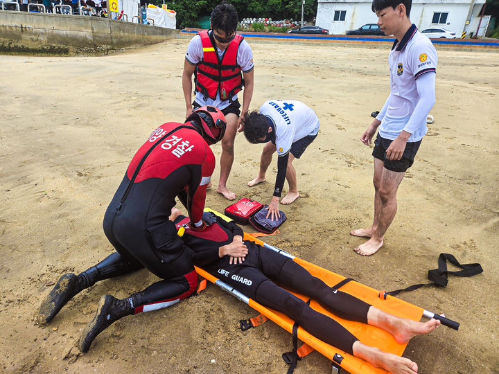 [통영=뉴시스] 신정철 기자= 통영해양경찰서는 여름철 성수기 해수욕장 개장에 맞춰 지난 13일 통영시 도남동 수륙해수욕장에서 민·관 합동 구조 훈련을 전개했다.사진은 여름철 해수욕장 인명구조 훈련 모습.(사진=통영해경 제공).2026.07.14. photo@newsis.com *재판매 및 DB 금지