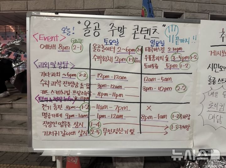 [서울=뉴시스] 서울 송파구 올림픽공원 핸드볼경기장 봉쇄 집회 현장에 설치된 '올공 주말 콘텐츠' 안내판. 안내판에는 기타·수학 과외와 진로 상담, 예배, 멸공카페, 직장인 업무존, 전기 충전, 태극기 바느질 등 주말 프로그램과 운영 장소·시간이 적혀 있다. (사진=SNS 캡처) 2026.07.14. photo@newsis.com