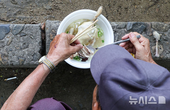 [대구=뉴시스] 이무열 기자 = 초복을 하루 앞두고 폭염이 연일 이어진 14일 대구 달서구 두류공원 사랑해밥차 무료급식소를 찾은 한 어르신이 삼계탕을 먹고 있다. 2026.07.14. lmy@newsis.com