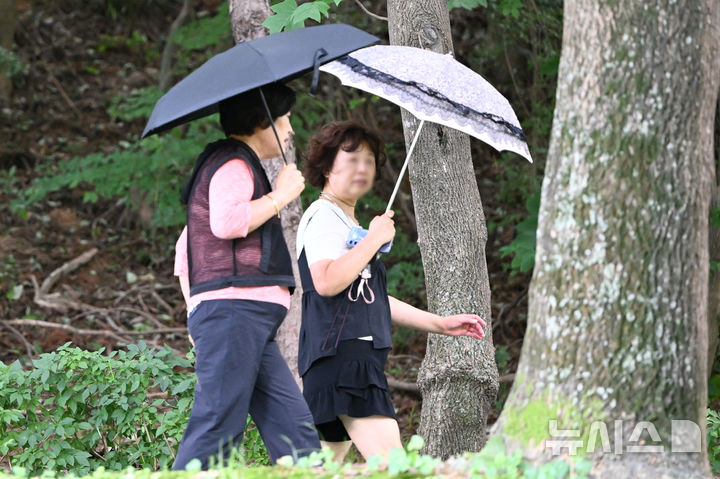 [전남광주=뉴시스] 이현행 기자 = 14일 오후 전남광주 일부 지역에 폭염 특보가 내려진 가운데 서구 쌍촌동 5·18기념공원에서 시민들이 양산을 쓴 채 산책하고 있다. 이날 오후 2시 기준 전남광주 최고체감온도는 완도 청산도 34도, 광주 조선대 33.8도, 화순 33.2도, 곡성 33.1도, 담양 봉산·나주 다도 33도, 광양 광양읍 32.9도, 영암 시종 32.7도, 곡성 석곡 326도, 무안 운남 32.5도, 구례 32.4도 등의 분포를 보이고 있다. 2026.07.14. lhh@newsis.com