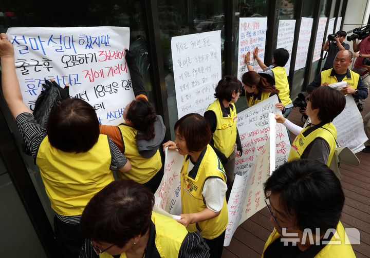 [서울=뉴시스] 이영환 기자 = 안수용 마트산업노동조합 홈플러스지부장과 조합원 등이 14일 오후 서울 강서구 홈플러스 본사 앞에서 MBK의 일방적 면담 취소 규탄 및 노동조합 입장 발표 기자회견을 마친 후 본사 입구 인근에 규탄 문구가 적힌 대자보를 붙이고 있다. 2026.07.14. 20hwan@newsis.com