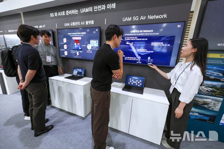 [서울=뉴시스]KT가 K-UAM 원팀 소속으로 현대자동차, 현대건설, 인천국제공항공사, 대한한공과 함께 구성한 공동 부스에서 관계자들이 KT의 UAM 기술을 살펴보고 있다. (사진=KT 제공)