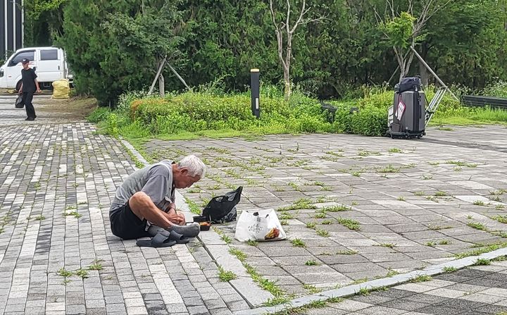 [수원=뉴시스] 최유리 인턴기자=한 노숙인이 맨바닥에 앉아 도시락을 먹는 모습.&nbsp; *재판매 및 DB 금지
