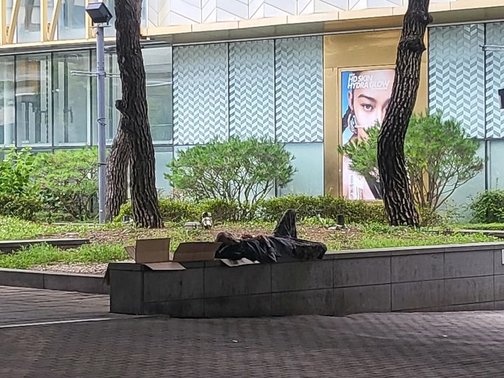 [수원=뉴시스] 최유리 인턴기자=수원역 롯데백화점 앞에서 노숙인이 벤치에 파지를 깔고 잠을 자고 있다. *재판매 및 DB 금지