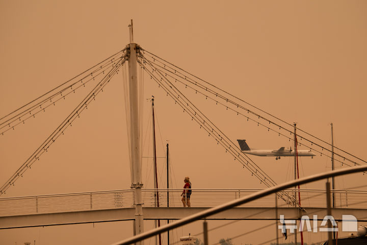 A plane lands at Billy Bishop Toronto City Airport as wildfire smoke fills Toronto, on Wednesday, July 15, 2026. (Laura Proctor/The Canadian Press via AP)