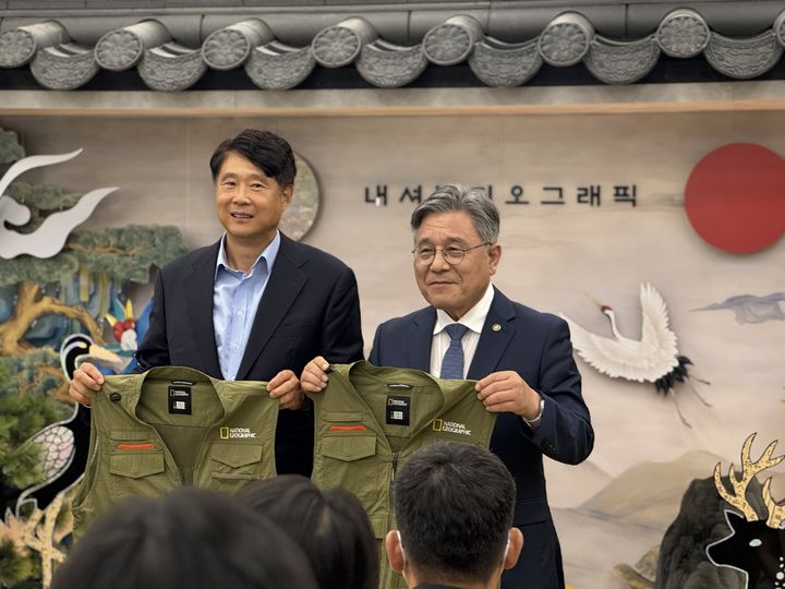 [서울=뉴시스] 박영준 더네이쳐홀딩스 대표(왼쪽)와 허민 국가유산청장이 세계유산위원회 운영 스태프 공식 의상을 들어보이고 있다. (사진=동효정 기자) 2026.07.16. vivid@newsis.com *재판매 및 DB 금지