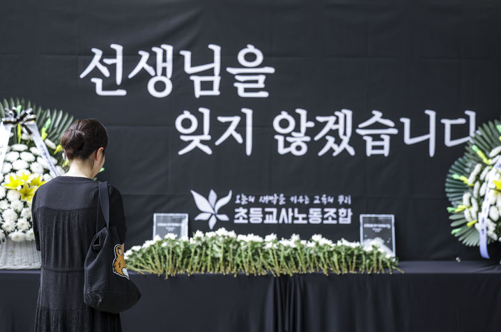 [서울=뉴시스] 정병혁 기자 = 서이초 순직교사 1주기인 2024년 7월 18일 서울 서초구 서울교육대학교에서 열린 교사유가족협의회, 초등교사노동조합 2024 순직교사 추모행사를 찾은 교사 및 시민들이 헌화를 하고 있다. 2024.07.18. jhope@newsis.com *재판매 및 DB 금지