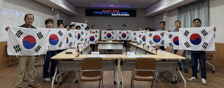 [창녕=뉴시스] 장마면 주민자치위원회 위원 태극기 달기 캠페인을 하고 있다. (사진= 창녕군 제공) 2026.07.16. photo@newsis.com *재판매 및 DB 금지