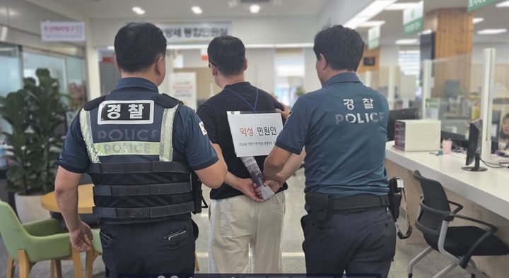 [장수=뉴시스] 전북 장수군은 특이민원 발생 대비를 위해 '악성민원 대응 모의훈련'을 진행했다고 16일 밝혔다. 악성 민원인 역할을 하는 인물이 훈련 마무리 단계에서 경찰에게 제압돼 이동되고 있다. (사진=장수군 제공) 2026.07.16. photo@newsis.com *재판매 및 DB 금지
