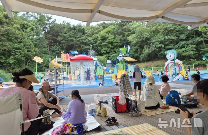 [울산=뉴시스] 19일 울산대공원 야외물놀이장을 찾은 시민들이 그늘에 앉아 더위를 식히고 있다. 2026.07.17 gorgeouskoo@newsis.com